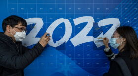 BEIJING, CHINA - APRIL 12: A man takes a photo of a woman as she signs a '2022' poster at an event held by the organizing committee of the Beijing 2022 Winter Olympics and Paralympics for international media at their headquarters at Shougang on April 12, 2021 in Beijing, China. The committee recently held test events at several venues ahead of the Winter Games set to open February 4, 2022.  (Photo by Kevin Frayer/Getty Images)
