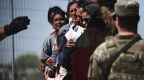 A member of the Texas Army National Guard watches as US Customs and Border Protection Border Patrol agents search migrants surrendering themselves for the processing of immigration and asylum claims on the US-Mexico border in El Paso, Texas.