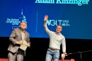 Two men stand on a stage with a WGLT and Dirksen Congressional Center logos int he background. 