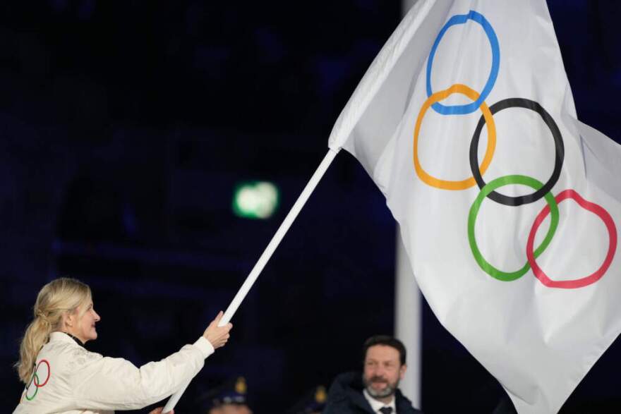 President of the Provence-Alpes-Cote d'Azur Region Renaud Muselier, right, and President of the Auvergne-Rhone-Alpes Region Fabrice Pannekoucke wave the Olympic flag during the closing ceremony of the 2026 Winter Olympics, in Verona, Italy, Sunday, Feb. 22, 2026. (Natacha Pisarenko/AP)
