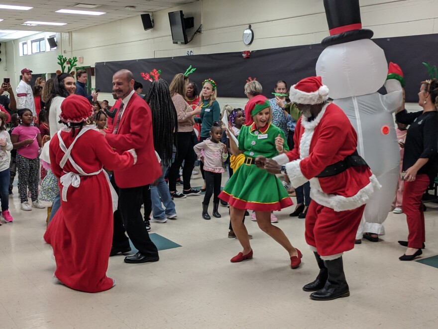 Several people dance while dressed festively.