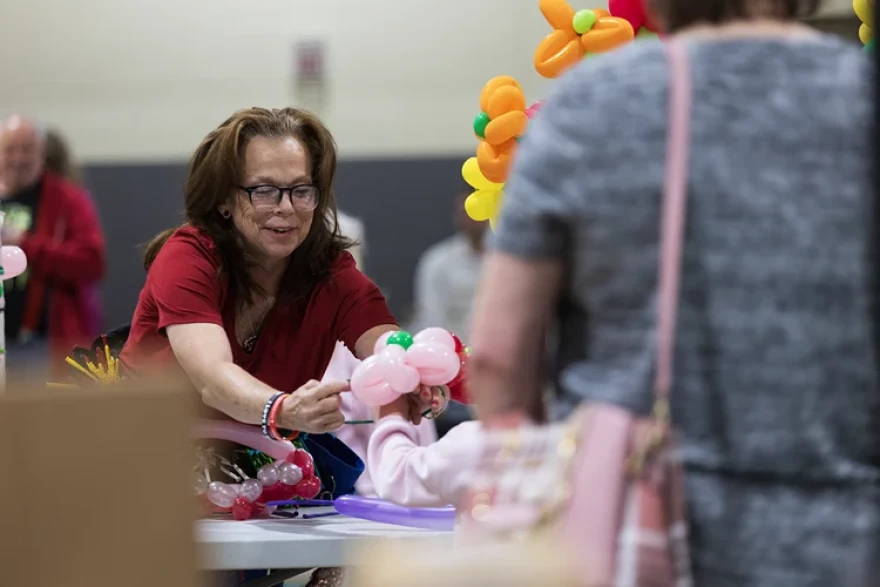 The Balloon Twister vendor Stephanie Neal puts a flower bracelet made out of balloons around a child’s wrist during the annual Spring Craft Fair April 18. Neal charged 50 cents per balloon used to ensure every child had the opportunity to get one.
