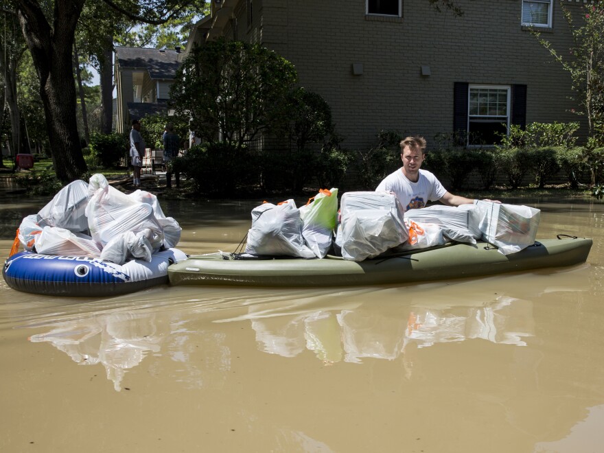A resident tries to save some of his belongings from the flooded Buffalo Bayou in Houston.