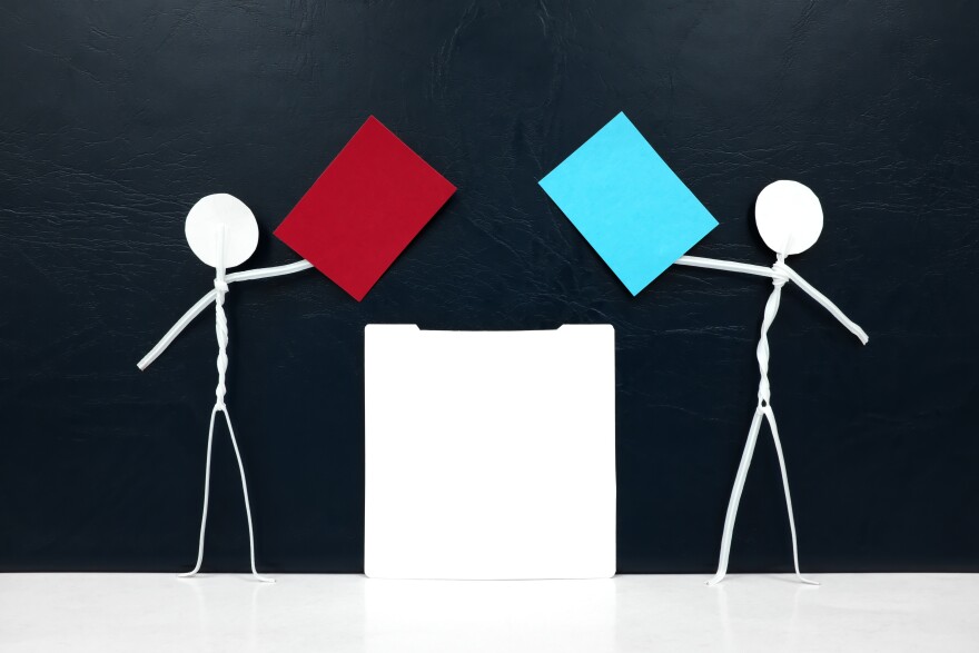 Stick men holding red and blue paper ballot beside a cartoon voting machine