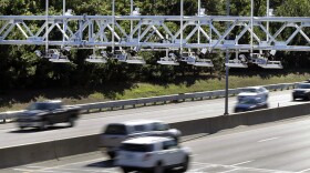 FILE - In this Aug. 22, 2016 file photo, cars pass under toll sensor gantries hanging over the Massachusetts Turnpike in Newton, Mass. 