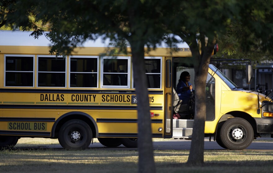 A Dallas Independent School District bus departs L.L. Hotchkiss Elementary school after dropping off students, Thursday, Oct. 2, 2014, in Dallas.