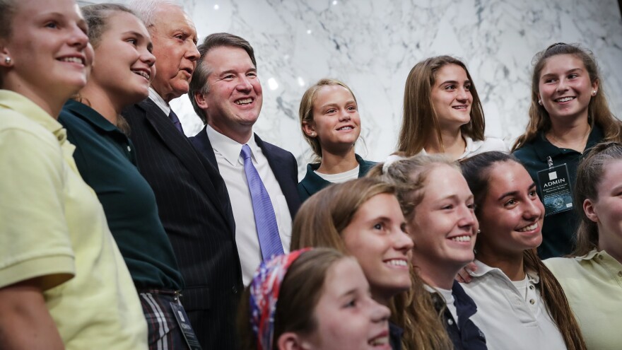 Supreme Court nominee Judge Brett Kavanaugh poses for photos with young basketball players he has coached, during a break in his Senate Judiciary Committee hearings Thursday.