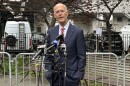 Rick Scott speaking into microphones outside a park
