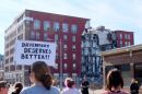Protesters stand out the collapse site of an apartment building in Davenport on May 30. 