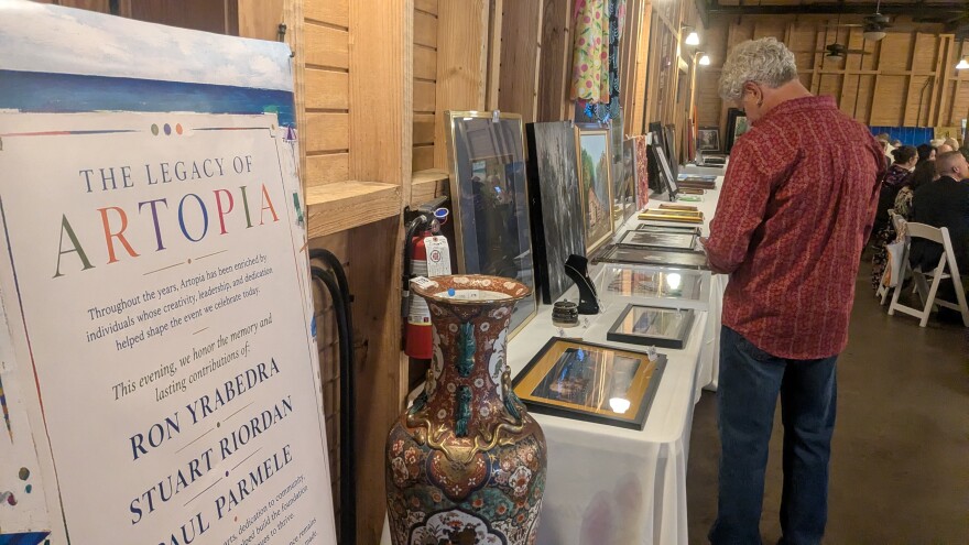 A prospective bidder inspects the vast selection of artistic offerings at Artopia