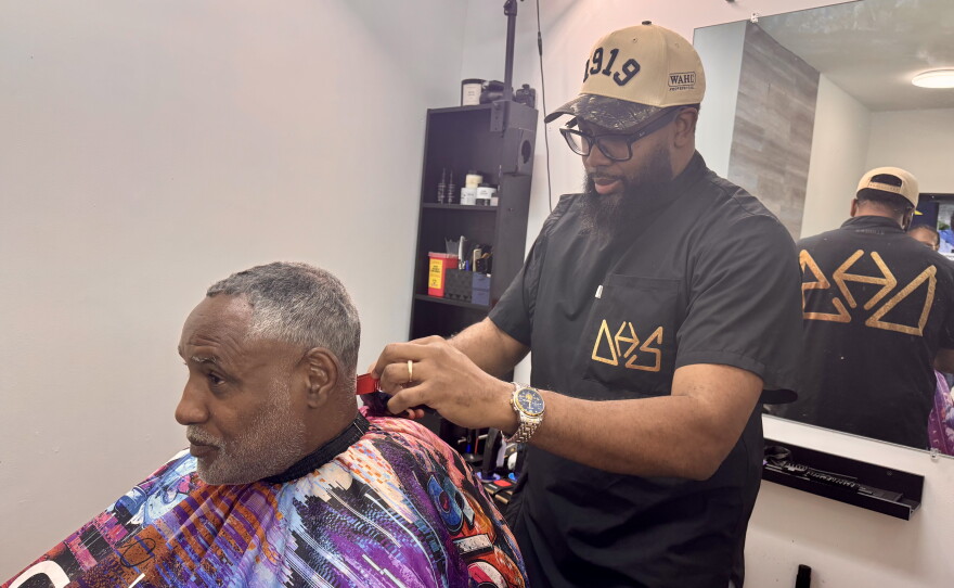 Barber and salon co-owner Nate Williams gives client Mario Brown, an OurHAIR trainer, a haircut.