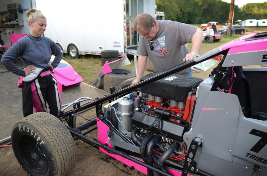 Lone Jack racer Casey Baker watches mechanic Lloyd Dickey as he examines a broken high-pressure oil hose in Baker’s sprint car. Baker blew the hose in her first outing on the track but returned to race in later events.