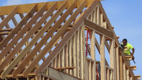 A construction worker uses a tool on the roof line of a home being built in Brick N.J. on July 10, 2023.