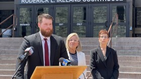 Standing before the Roderick L. Ireland Courthouse in Springfield, Mass., Thursday, July 23, 2026, attorney Zack Vargo (left, at podium) formally called on City Councilor Justin Hurst to cease what he has called a "sustained campaign of harassment" targeting Springfield City Clerk Gladys Oyola-Lopez (center, behind Vargo)