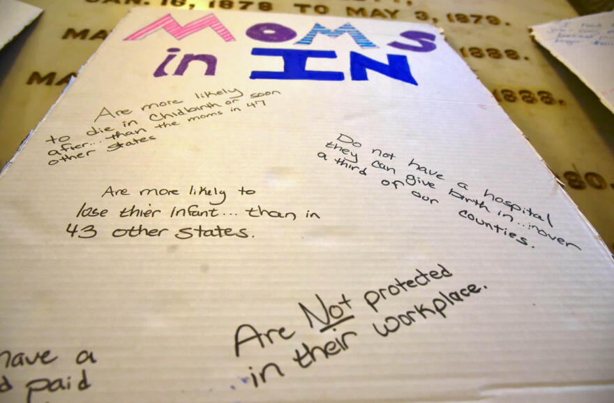 A sign from a rally at the Indiana Statehouse in 2021 says mothers in Indiana aren't protected in workplace and lists other statistics on maternal mortality. (Justin Hicks/IPB News)
