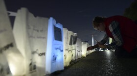 Dawn Scott of Cody, Wyo., a 20-year cancer survivor, photographs lighted bags in memory of friends and family who died of cancer during a "Lights of HOPE" ceremony in Washington, Tuesday, Sept. 25, 2018. (Susan Walsh/AP)