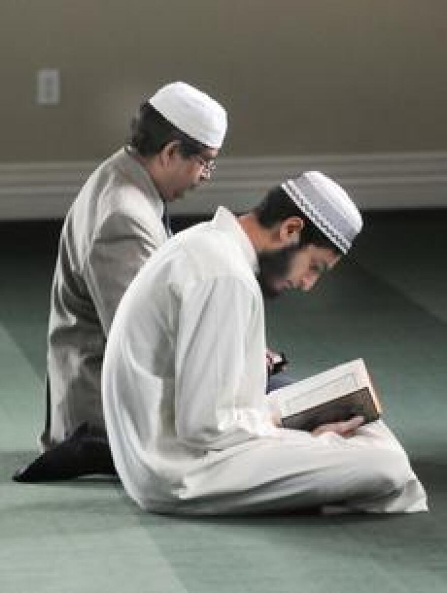 A pair of men read from the Qur'an as part of their prayers during Friday's Jumma Prayer at the Islamic Center in Elizabethtown.