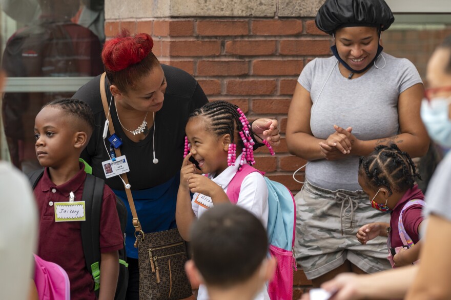 Lisa Moore says goodbye to her daughter Elizabeth Davis on her first day of kindergarten. The students and families of Rawson Elementary School in Hartford are greeted with enthusiasm by members of Calling All Brothers.