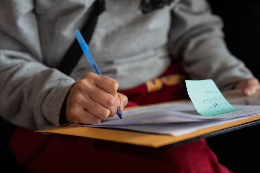 Close up of a hand signing a paper document