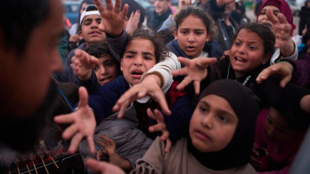Displaced families extend their hands while waiting for donated food beside the tents they use as shelters after fleeing Israeli bombardment in southern Lebanon, in Beirut, Lebanon, Thursday, April 9, 2026. (Emilio Morenatti/AP)