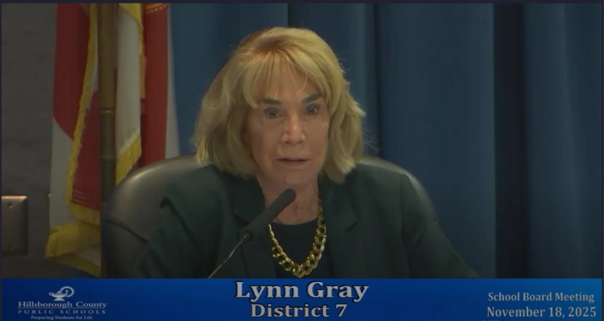 Mujer con traje oscuro y cadena de oro