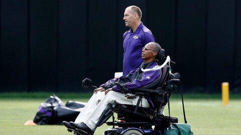 FILE - Baltimore Ravens senior advisor to player engagement O.J. Brigance, bottom, watches an NFL football training camp practice in Owings Mills, Md., Aug. 8, 2017. (AP Photo/Patrick Semansky, File)