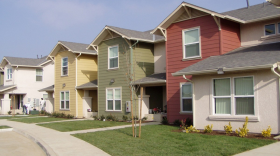 Image of the outside of a row of houses in a neighborhood.