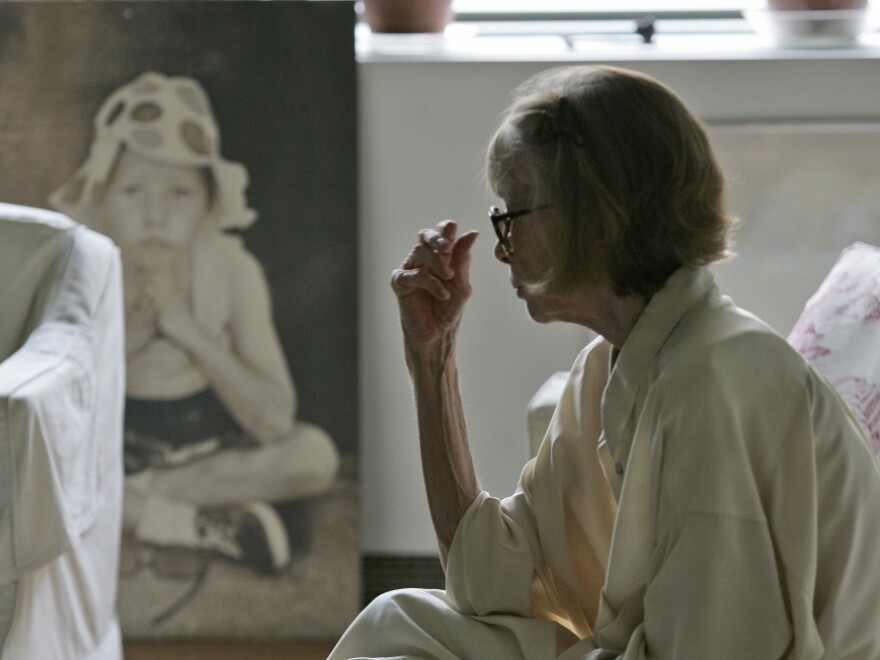 <p>Didion looks at a painting of her daughter in her New York apartment.</p>