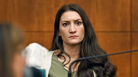 A woman sits in the witness box in a courtroom