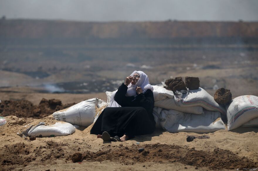 A Palestinian woman sniffs a fragrance to counter the effect of tear gas during clashes with Israeli security forces near the border between Israel and the Gaza Strip.