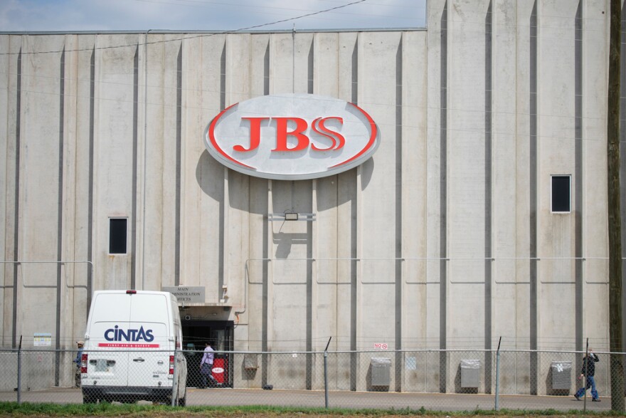 The exterior of a large blank build with a sign that says "JBS"