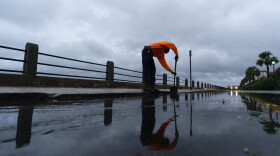 Corey Fields, with the city of Charleston, cleans a storm drain as effects from Hurricane Ian are felt in South Carolina. (Alex Brandon/AP)
