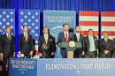 vp at a podium surrounded by signage about eliminating SNAP fraud