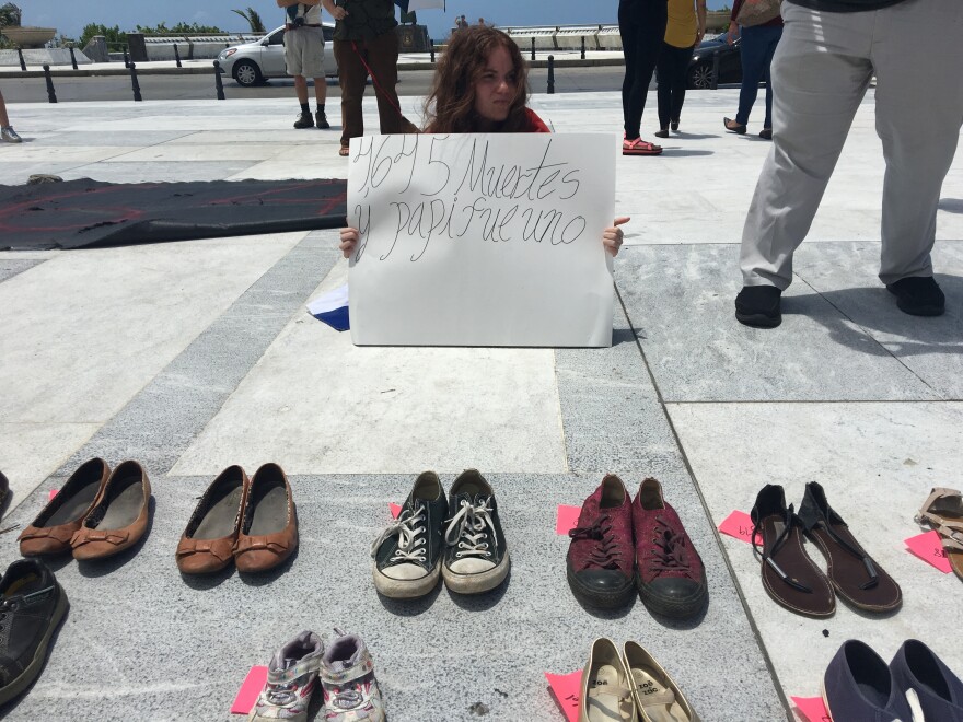 Luis Manuel Vázquez's daughter held a sign that read, "4,645 dead and my daddy was one of them."