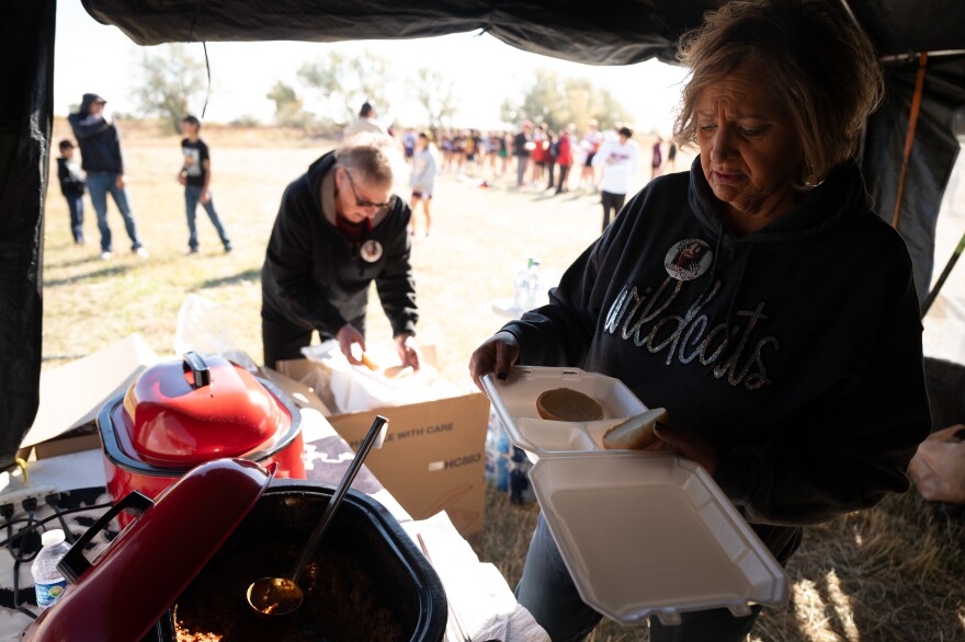 Tescha Hawley (right) and her mother, Janice Hawley, serve food from Tescha’s nonprofit to cross-country teams at the Harlem Invitational in Harlem, Montana. Tescha began the Day Eagle Hope Project to improve the health of her community after seeing how hard it was to access care when she was diagnosed with cancer in 2016. (Jessica Plance for KFF Health News)