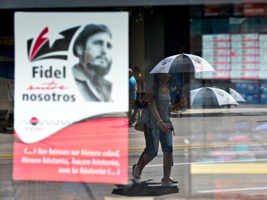 A woman in Havana walks next to a poster about Cuban former President Fidel Castro in August.