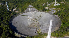 This aerial view shows the damage at the Arecibo Observatory after one of the main cables holding the receiver broke in Arecibo, Puerto Rico, on Dec. 1, 2020. The radio telescope in Puerto Rico, which once starred in a James Bond film, collapsed Tuesday when its 900-ton receiver platform fell 450 feet (140 meters) and smashed onto the radio dish below. (Ricardo Arduengo/AFP via Getty Images)