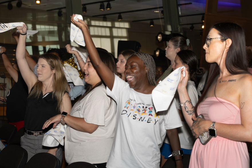 Family and friends cheer on their loved ones as they walk down the runway
