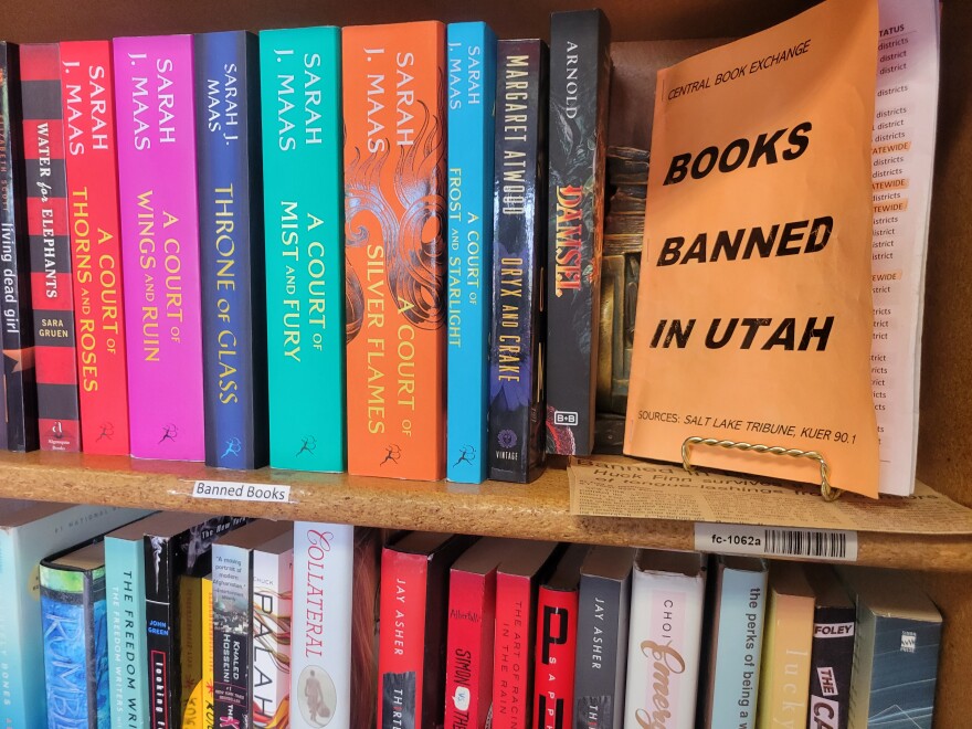 FILE - A photo of a shelf at a local bookstore in Utah features a few books that are banned in K-12 schools across the state.