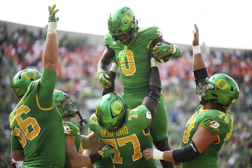 Oregon running back Jordon Davison (0) is congratulated after his touchdown by offensive linemen Trent Ferguson (56), Matthew Bedford (77), Charlie Pickard (70) and others during the second half of an NCAA college football game against Oklahoma State, Saturday, Sept. 6, 2025, in Eugene, Ore.