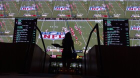 A waitress carries an order as fans watch the Super Bowl 58 NFL football game on screens at a sportsbook, Sunday, Feb. 11, 2024, in Las Vegas. (AP Photo/Gregory Bull)