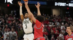 Michigan State guard Jaden Akins (3) shoots a three-point basket over New Mexico guard CJ Noland, right, in the second half in the second round of the NCAA college basketball tournament, Sunday, March 23, 2025, in Cleveland. 