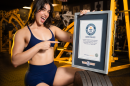 Lilian Zamora Alonso posing with the Guiness World Record certificate for heaviest weighted hip thrust by a woman.