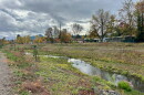 A stream runs between a bike path and a street