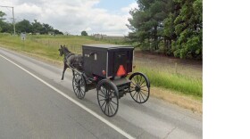 A horse-drawn cart moves along State Road 4 in Elkhart County, near the spot where police say 40-year-old Jason Hoover, driving a pickup truck, on Friday, Feb. 20 struck a horse-drawn buggy carrying four juveniles. Two of the children were killed and two have been hospitalized.
