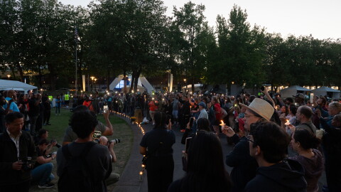 People gather for a vigil at dusk.