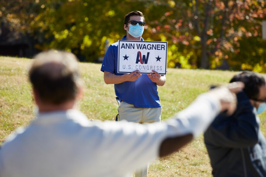 A supporter for Congresswoman Ann Wagner holds a campaign sign for the Republican outside her local polling site at Ballwin Golf Course and Events Center on Election Day.