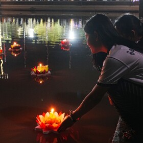 A girl floats candle lights in a pond to mark Meak Bochea Day, in Wat Phneat Sampily in a suburb of Phnom Penh, Cambodia, Monday, Feb. 2, 2026, as held in veneration of Buddha. (AP Photo/Heng Sinith)