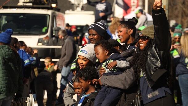 Seahawks fans pose for photos during the team's Super Bowl victory parade on Wednesday. Fans filled 4th Ave. to cheer their team on and catch a glimpse of their favorite players.