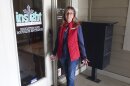 Bridgit Smith, executive director of the Insight Women's Center stands outside the door to its educational and "Boutique" with clothes and other supplies for new parents, Tuesday, Jan. 31, 2023, in Lawrence, Kansas. The center provides a variety of free services, including pregnancy tests, limited sonograms, and parenting and money-management counseling.  